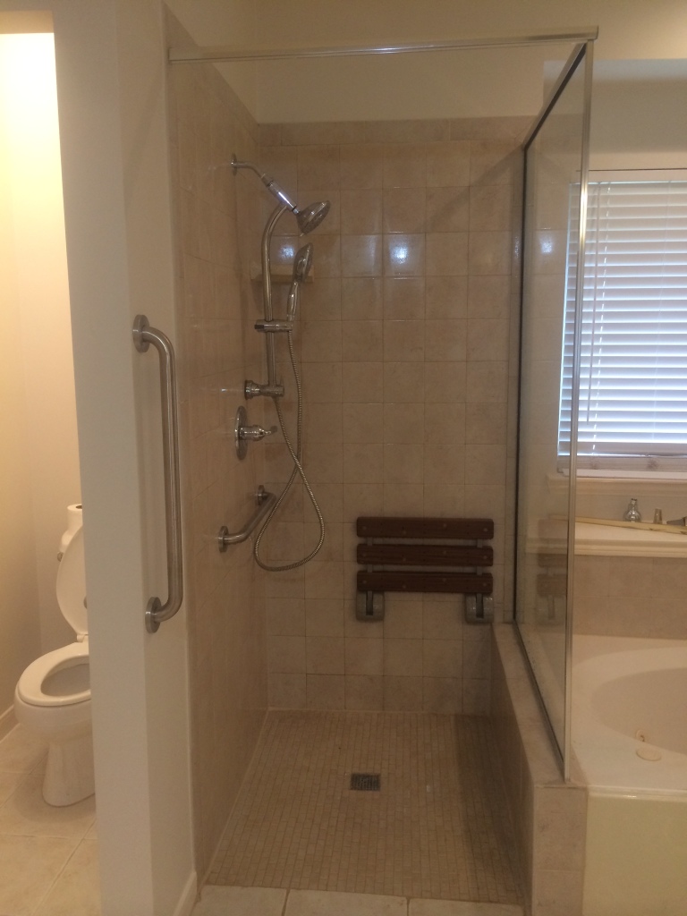 ada compliant bathroom with shower seat and grab bars