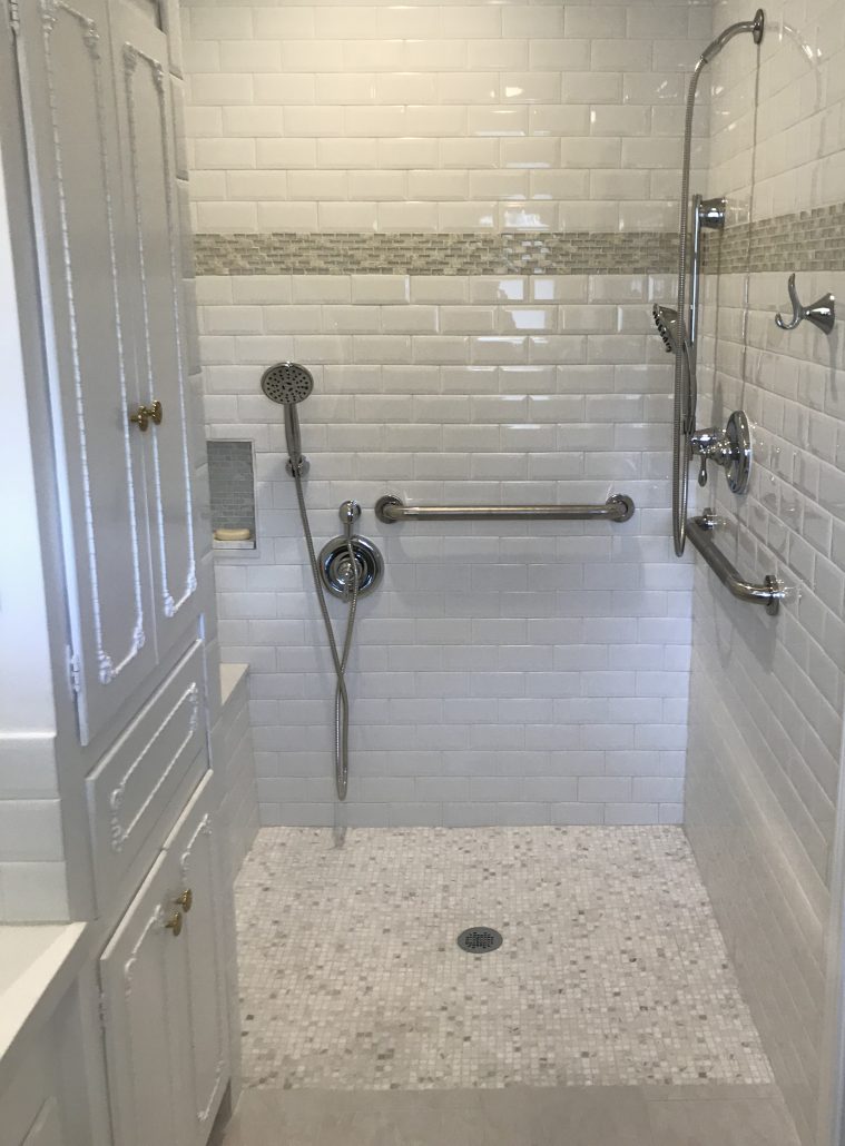 A remodeled ADA compliant bathroom with custom cabinets, floors, multiple shower heads and plumbing